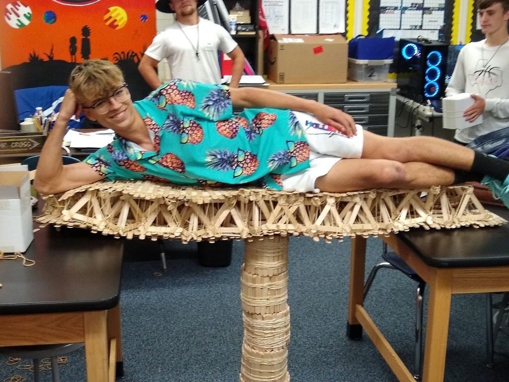 Jack Tannebaum lying on bridge of popsicle sticks